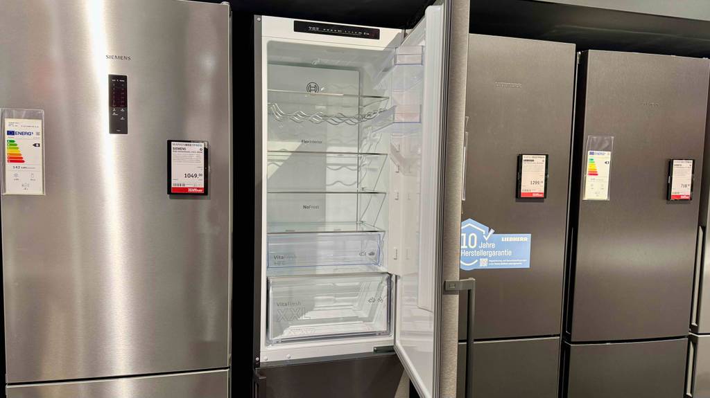 Im Test: Die Bosch-Kühl-Gefrierkombination steht mit geöffneter Kühlschranktür zwischen weiteren Kühl-Gefrierkombinationen in einem Elektrofachmarkt.