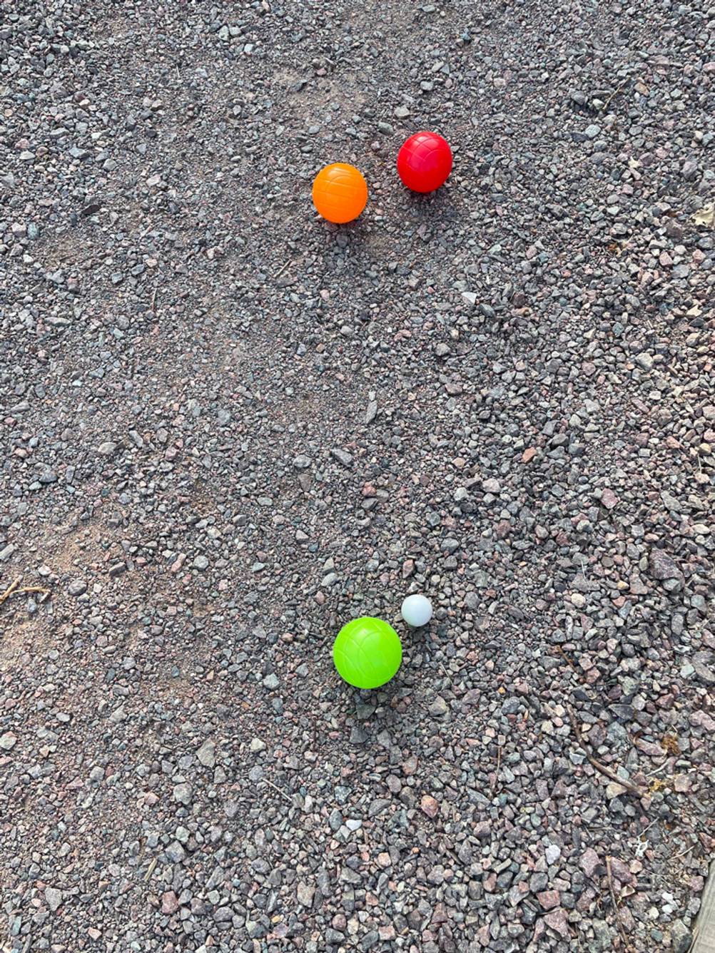 Getestete Boule aus verschieden farbigem Kunststoff liegen neben der weißen Zielkugel.