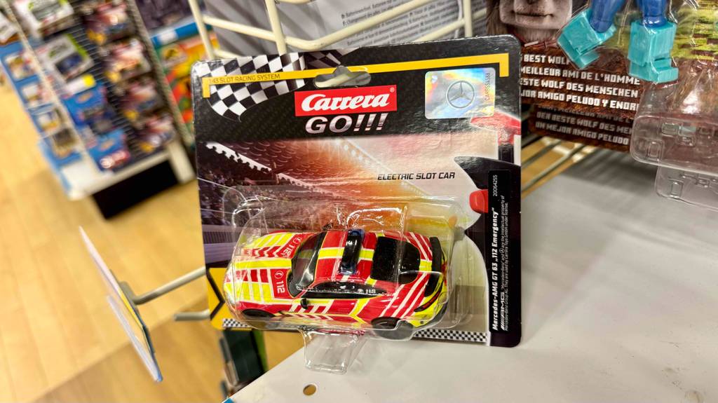 An einem Verkaufsständer lehnt die transparente Verpackung mit dem getesteten Carrera-Go-Auto.