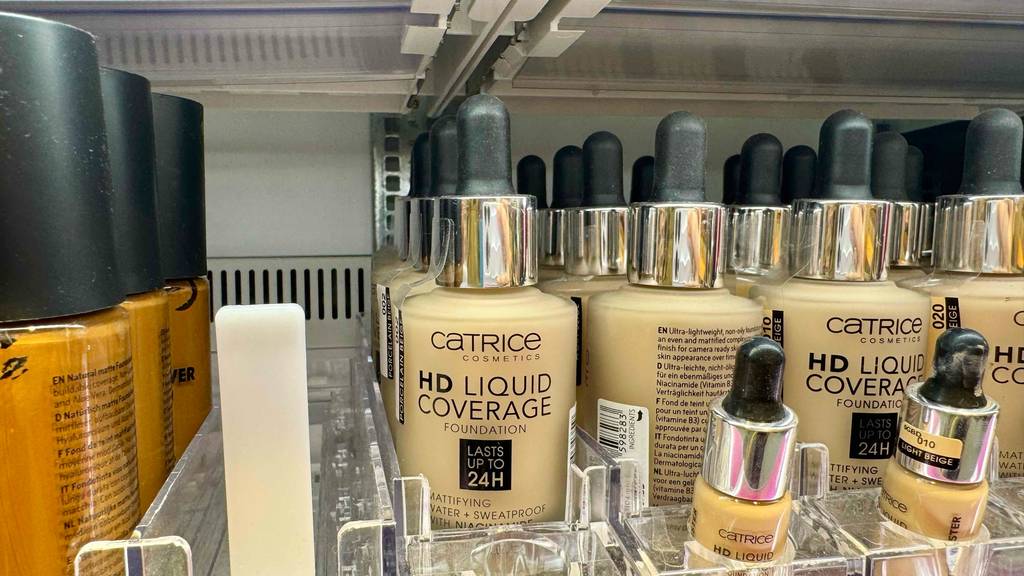 Getesteter Catrice-Concealer in Flaschen inklusive Pipetten befindet sich auf einem Verkaufsregal hinter Probe-Fläschchen.