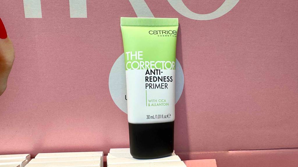 Getestet: Ein Catrice-Primer in der Tube steht vor einem rosafarbenen Plakat.