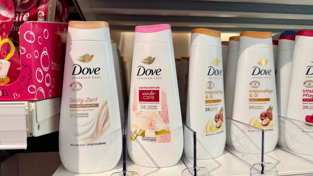 Getestet: Dove-Duschgel in der Kunststoff-Quetschflasche steht inmitten mehrerer Duschgele auf einem Regal im Drogeriemarkt.
