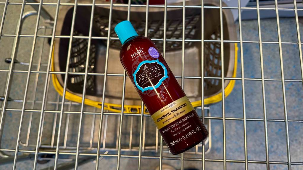Eine Quetschflasche mit Hask-Shampoo im Test liegt in einem Einkaufskorb.