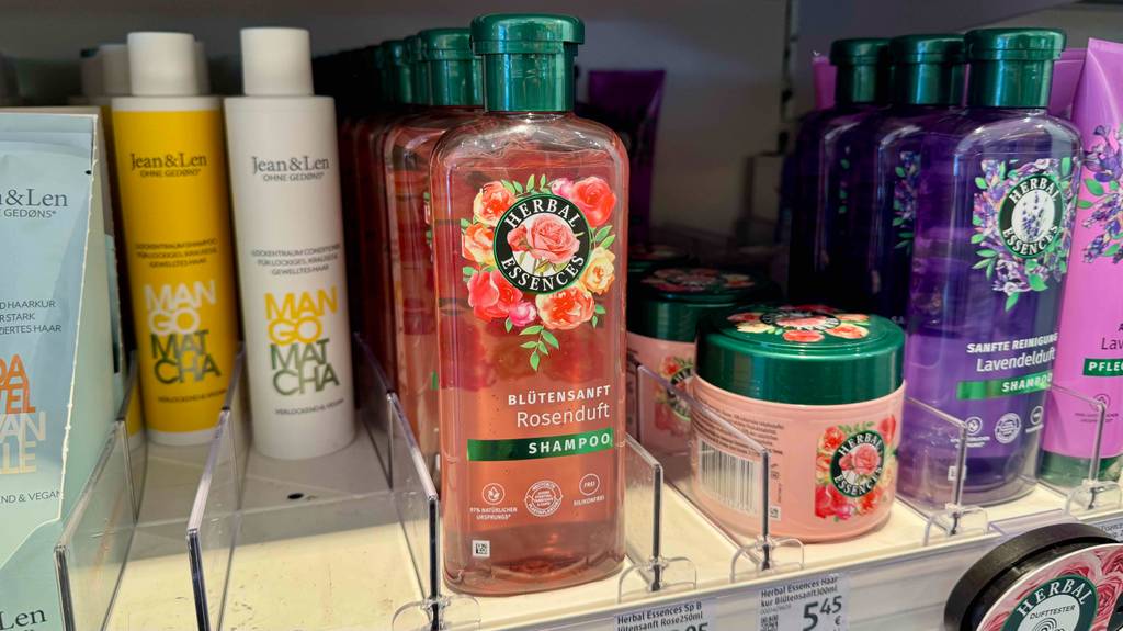Mehrere Flaschen mit Herbal-Essences-Shampoo im Test stehen in einem Verkaufsregal neben weiteren Shampoosorten.