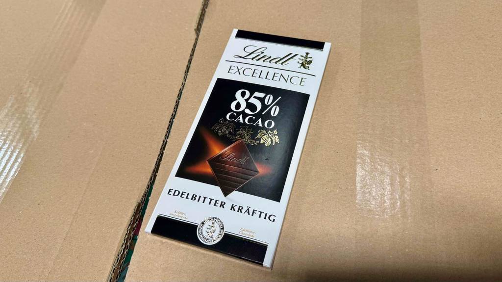 Lindt-Schokoladen im Test: Eine Tafel Schokolade Edelbitter kräftig liegt auf einer braunen Pappe.