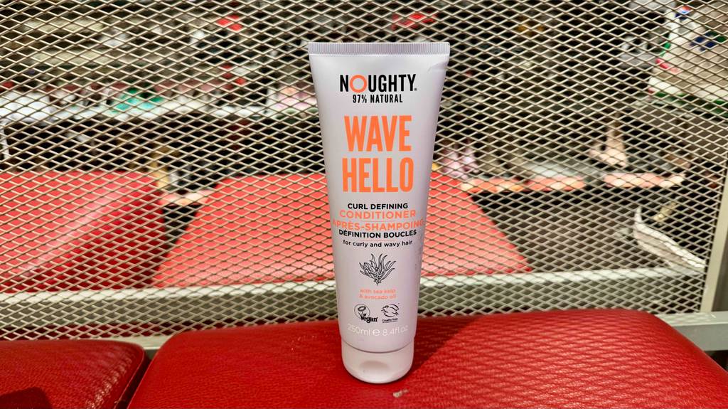 Im Test: Ein Locken-Conditioner in der weißen Tube steht auf einem roten Hocker im Geschäft.