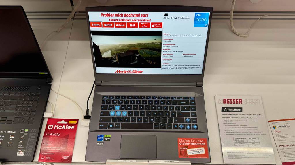 Ein getesteter MSI-Gaming-Laptop steht von oben betrachtet mit geöffnetem, eingeschaltetem Bildschirm auf einem Ausstellungsregal.