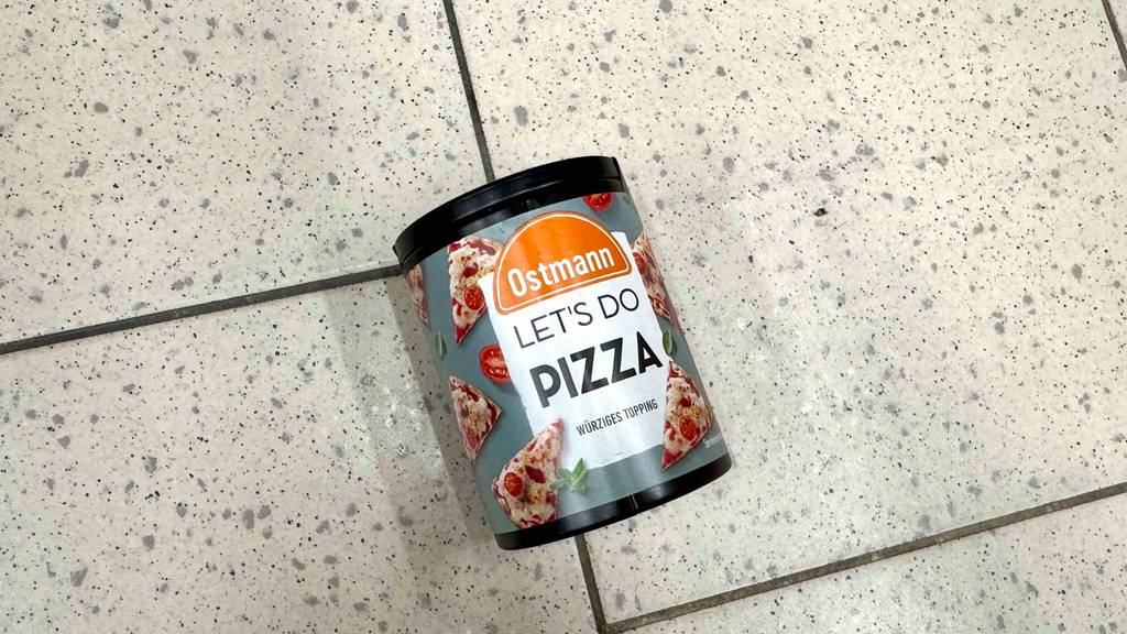 Getestet: Ostmann-Gewürz mit Pizza-Geschmack liegt in der Dose auf einem Fliesenbelag.