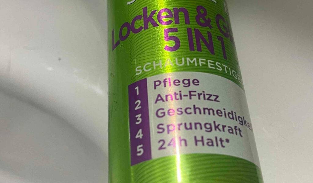 Nahaufnahme des giftgrünen Spenders inklusive Produktbeschreibung des Schaumfestigers für Locken im Test.