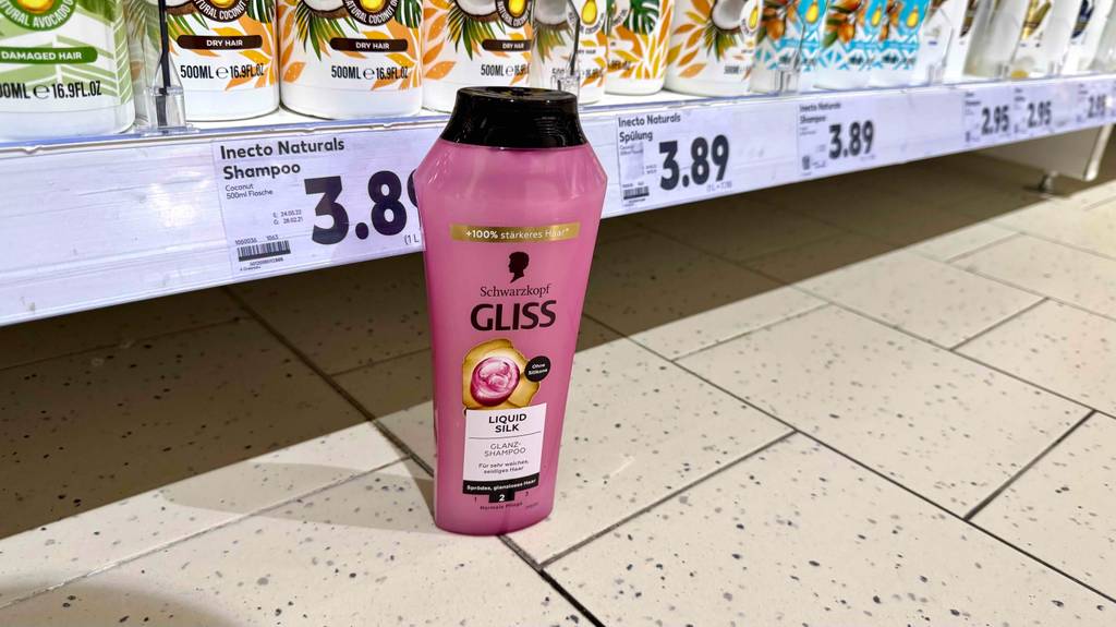 Getestet: Ein Schwarzkopf-Shampoo steht auf dem Boden vor einem Verkaufsregal mit Kosmetikprodukten im Drogeriemarkt.