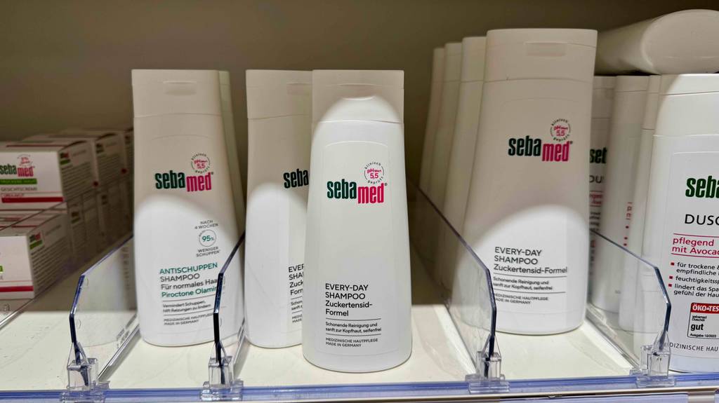 Sebamed-Shampoo im Test: Mehrere weiße Quetschflaschen stehen in einem Regal.
