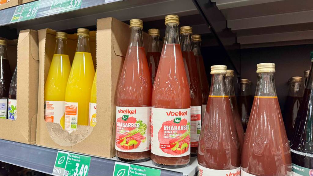 Voelkel-Saft im Test: Mehrere Glasflaschen stehen auf einem Regal im Supermarkt.