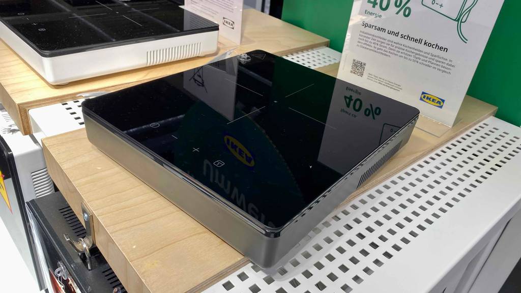 Schwarzes, tragbares Induktionskochfeld im Test: Modell von Ikea steht im Verkaufsbereich neben einem zweiten Induktionskochfeld.