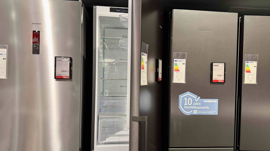 Die silberfarbige getestete Bosch-Kühl-Gefrierkombination mit hervorstehendem Handgriff steht zwischen mehreren Kühl-Gefrierkombinationen anderer Marken.