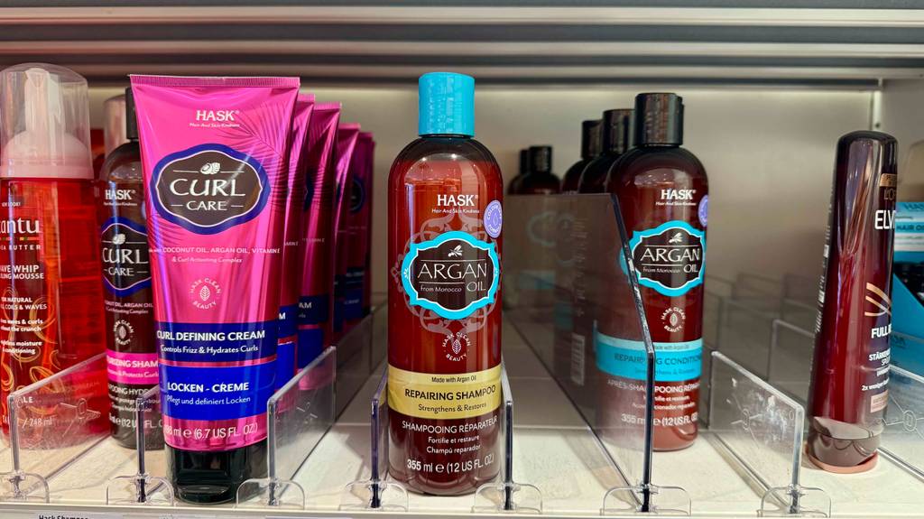 Mehrere braune Quetschflaschen mit getestetem Hask-Shampoo stehen in einem Einkaufsregal.