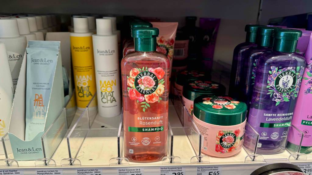 Neben unterschiedlichen Shampoo-Flaschen stehen getestete Herbal-Essences-Shampoos auf einem Regal im Drogeriemarkt.