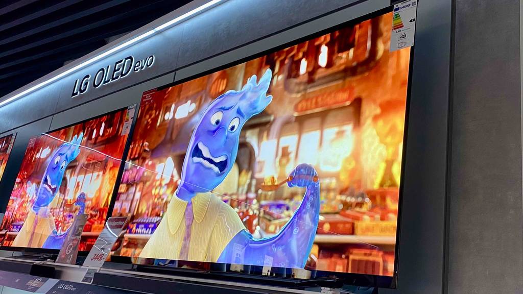 Seitliche Nahaufnahme von unten von zwei LG OLED-TVs im Test, die in einem Verkaufsbereich stehen.