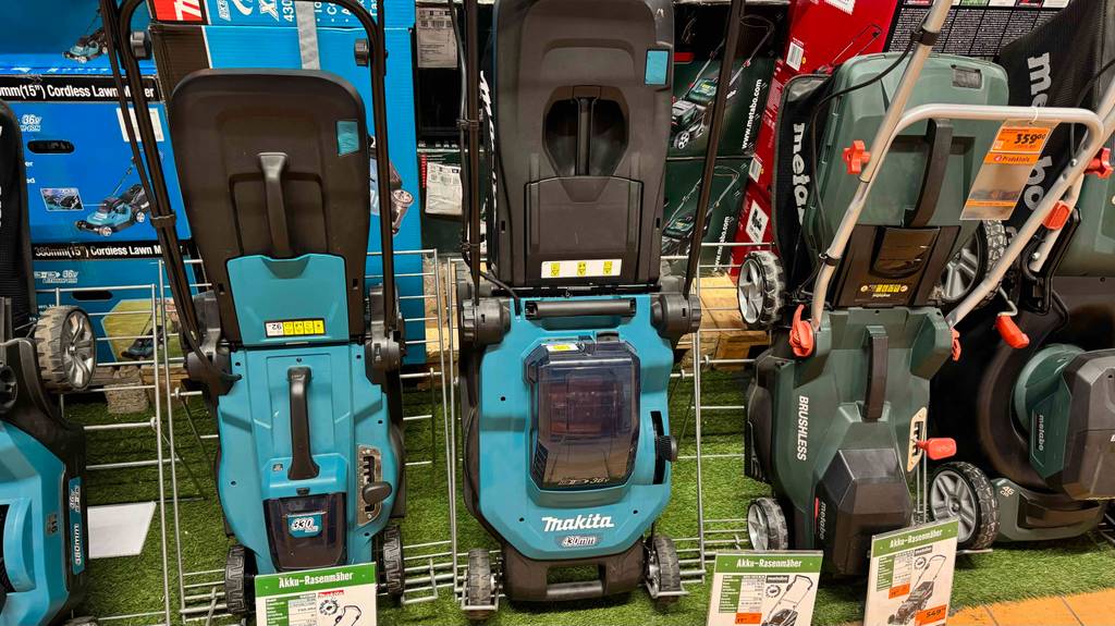 Der Makita-Rasenmäher Test-Kandidat steht von oben betrachtet in einer Reihe mit weiteren Rasenmäher-Modellen.