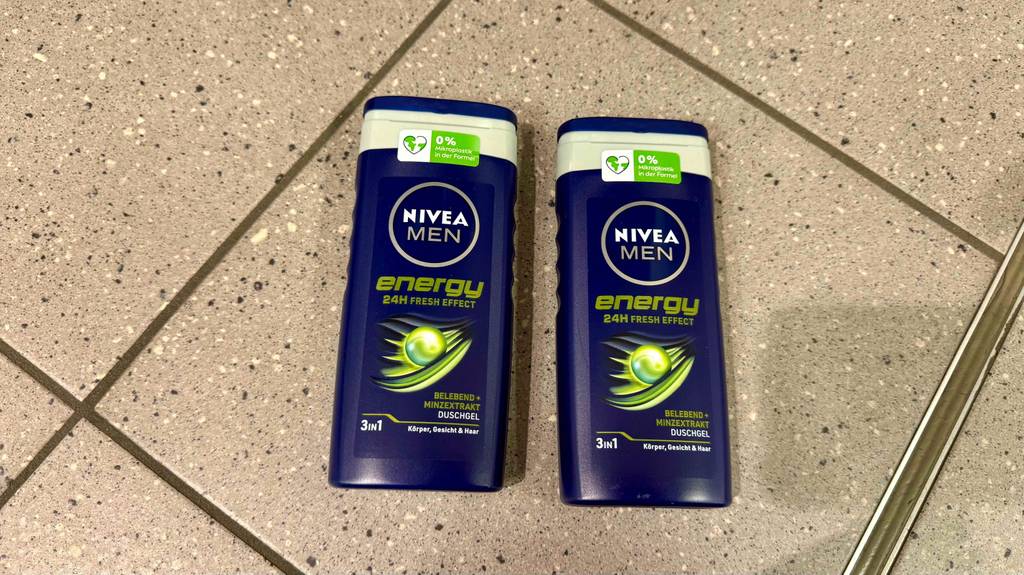 Getestet: Nivea-Duschgel für Männer in zwei dunkelblauen Quetschflaschen liegt auf einem Fliesenbelag.