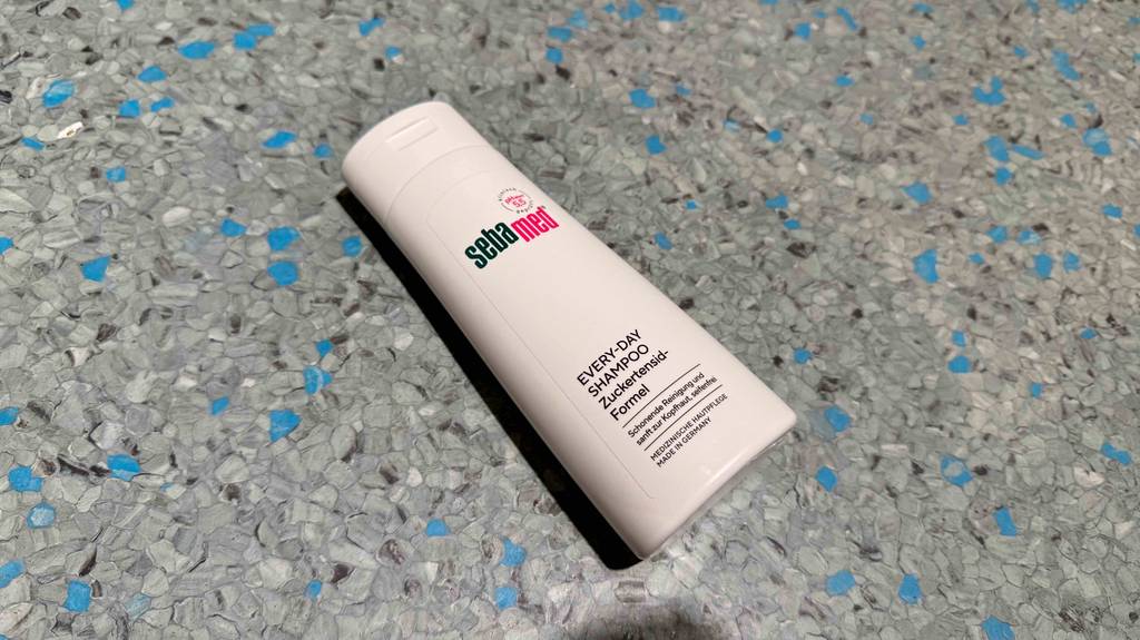 Getestet: Sebamed-Shampoo in einer weißen Quetschflasche liegt auf einem Linoleumboden.