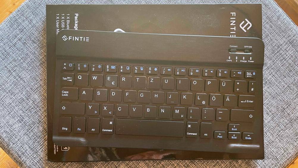 Eine schwarze getestete Tablet-Tastatur der Marke FINTIE steht auf seiner Verpackung.