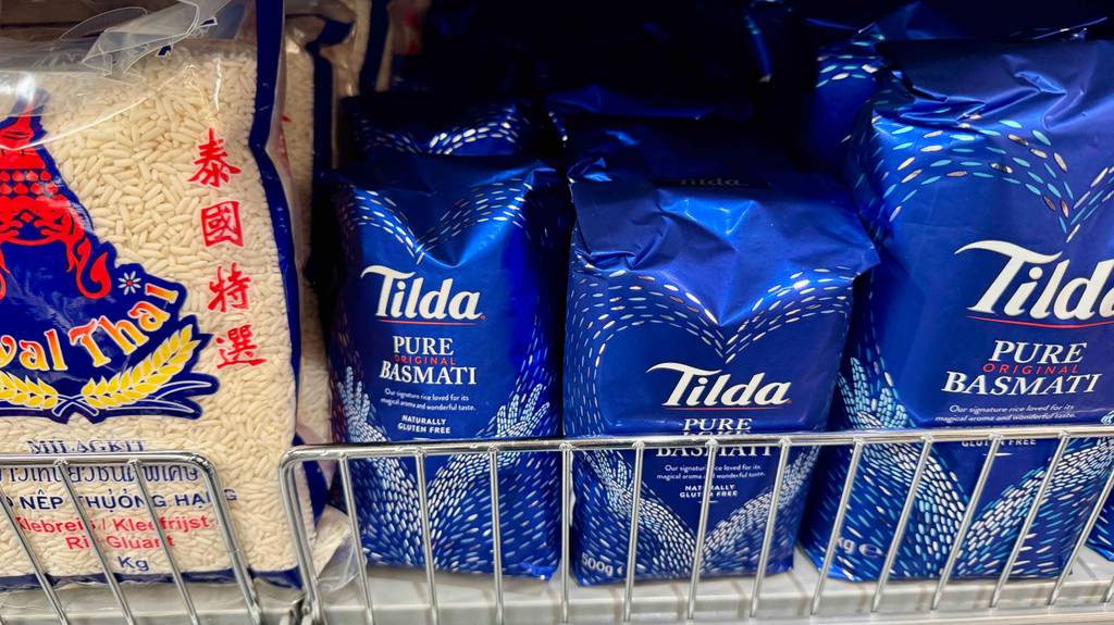 Mehrere blaue 500-g-Packungen mit Tilda-Reis im Test befinden sich in einem Verkaufsregal.