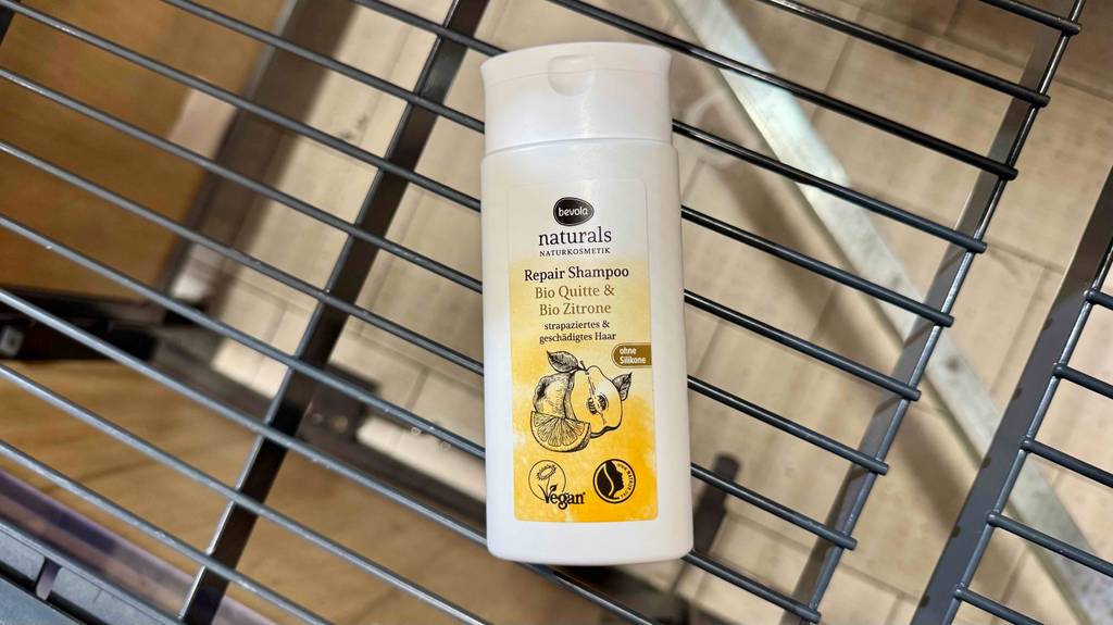 Ein getestetes veganes Shampoo in einer weißen Kunststoffflasche liegt in einem Einkaufskorb.
