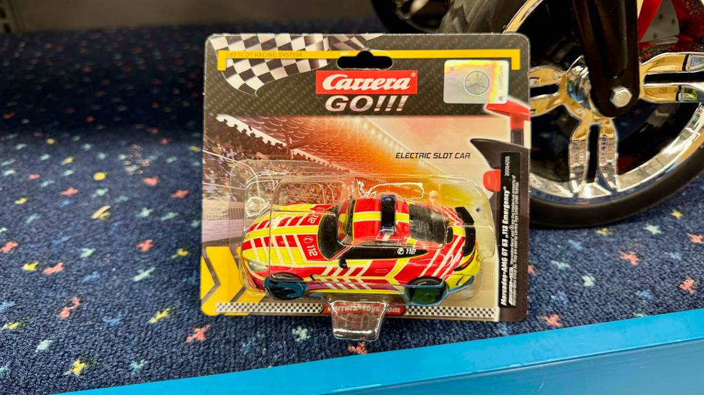Das Carrera-Go-Auto im Test liegt innerhalb der transparenten Verpackung auf einem blauen Teppich.