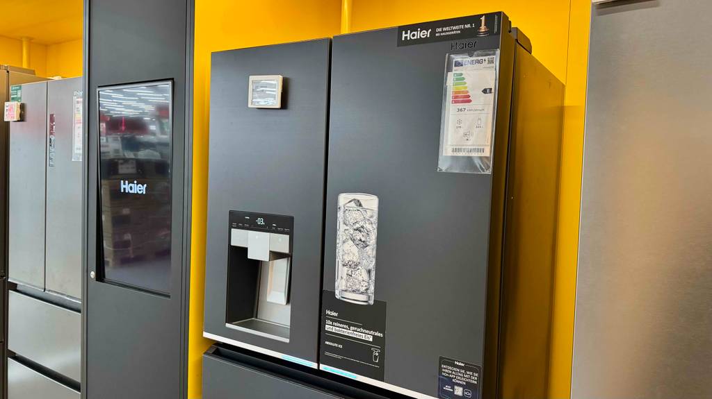 Side-by-Side-Kühlschränke von Haier im Test: Der zweitürige Kühlschrank steht neben weiteren Kühlschränken in einem Geschäft. Der Fokus liegt auf dem externen Wasser- und Eisspender.