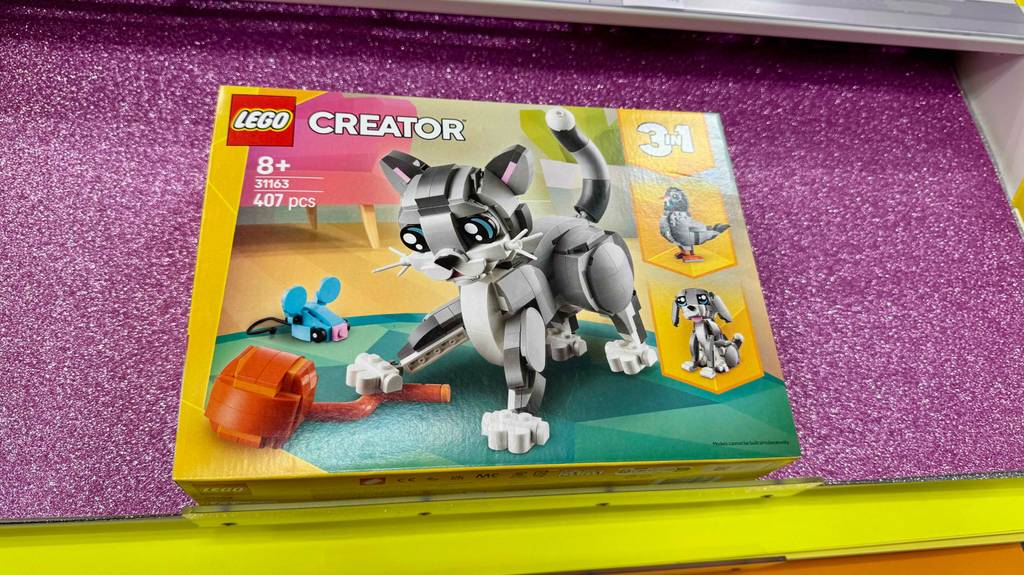 Eine Packung zum Bau von LEGO-Tieren im Test liegt auf einer pinkfarbenen Oberfläche.