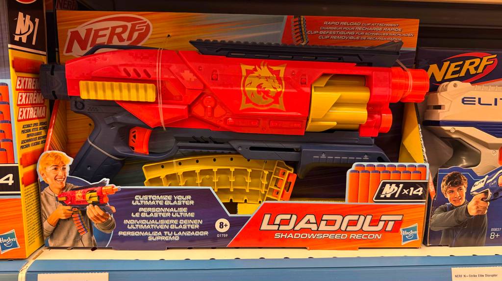 Nerf-Guns im Test: Eine rote Schaumstoffpfeil-Pistole befindet sich in ihrer Verpackung auf einem Verkaufsregal.