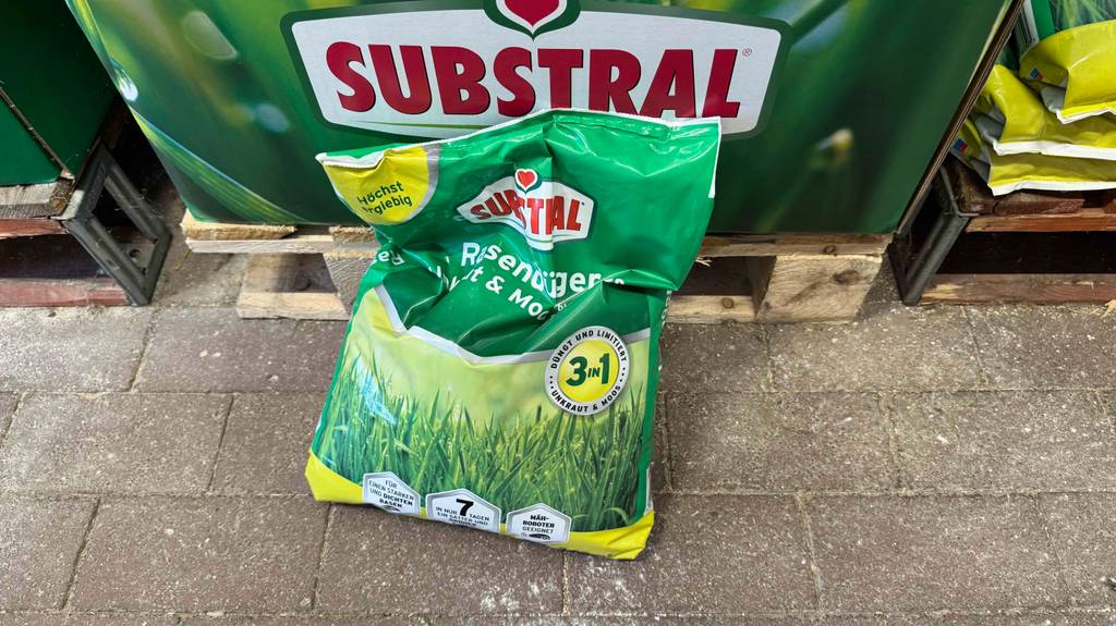 Der Substral-Rasendünger im Test befindet sich in einer 7,2-kg-Kunststofftüte vor einer Palette mit Dünger.