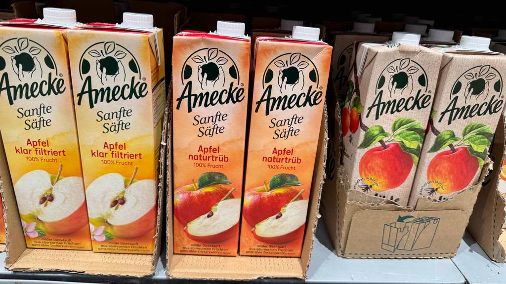 Getesteter naturtrüber Apfelsaft im Tetrapak der Marke Amecke steht auf einem Verkaufsregal neben weiteren Fruchtsäften.
