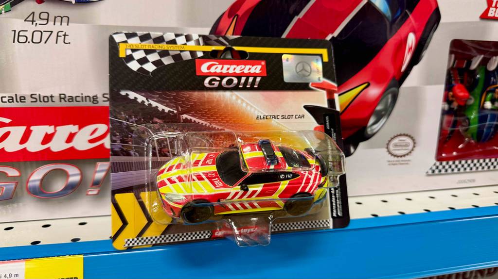 Das getestete Carrera-Go-Auto steht innerhalb der transparenten Verpackung vor dem Karton einer CARRERA-Rennbahn auf einem Verkaufsregal.