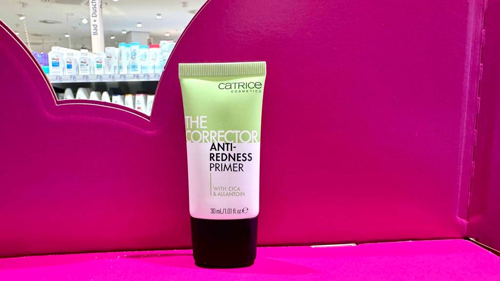 Catrice-Primer-Test: Eine Tube steht vor einem pinkfarbenen Hintergrund.