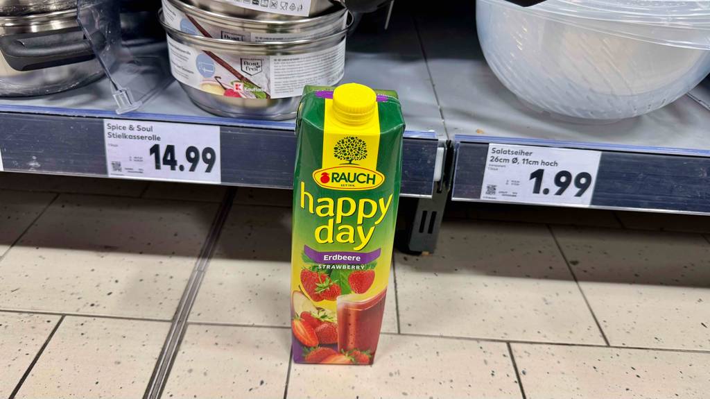 Happy-Day-Saft-Test: Ein Tetrapak von Rauch steht vor einem Regal mit Küchenutensilien.