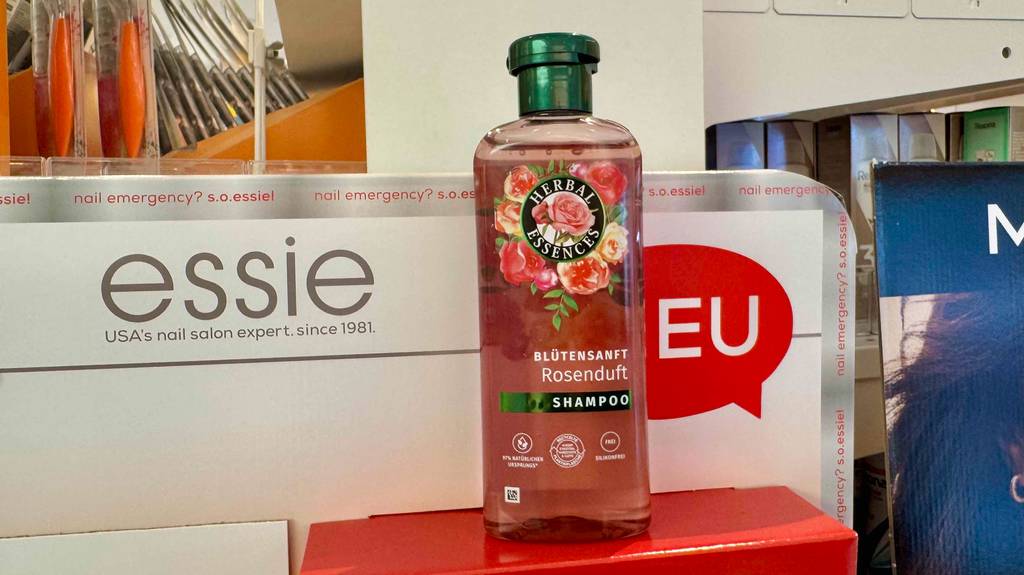 Eine Kunststoffflasche mit Herbal-Essences-Shampoo im Test steht auf einem roten Karton.