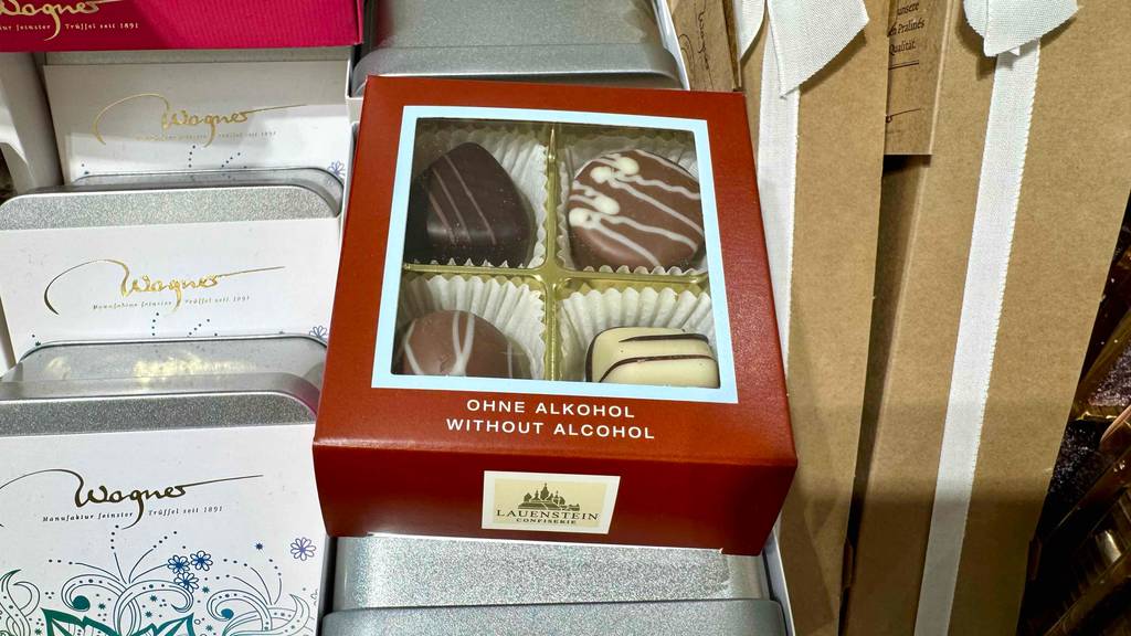Eine Packung mit vier Lauenstein-Pralinen im Test befindet sich auf einem Verkaufsregal mit weiteren verpackten Pralinen.