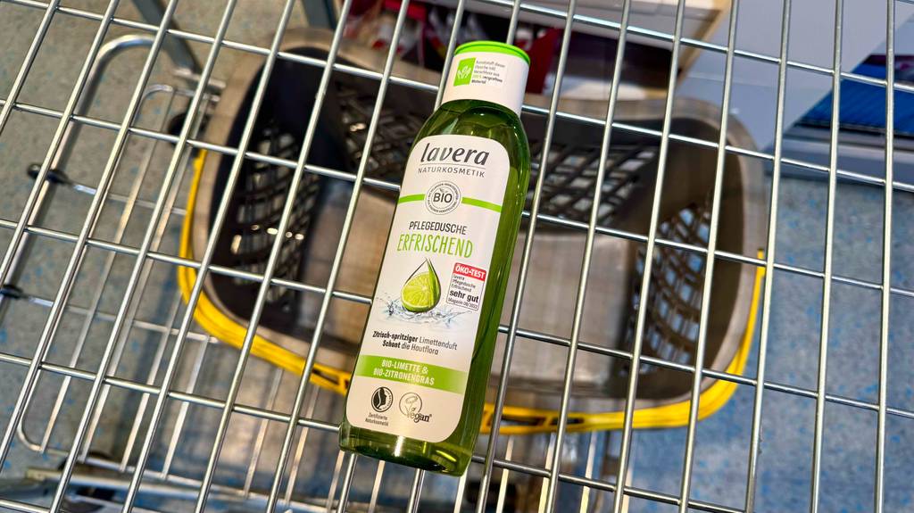 Eine transparente Quetschflasche mit Lavera-Duschgel liegt in einem Einkaufskorb.