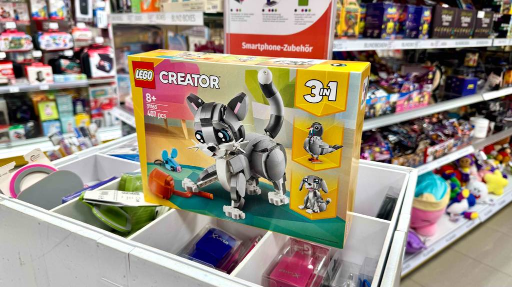 In einem Spielzeugladen steht eine Packung mit getesteten LEGO-Tieren, inklusive 407 Einzelteile zum Bauen einer Katze, eines Vogels oder eines Hundes, auf einer Schublade mit Spielzeugen.
