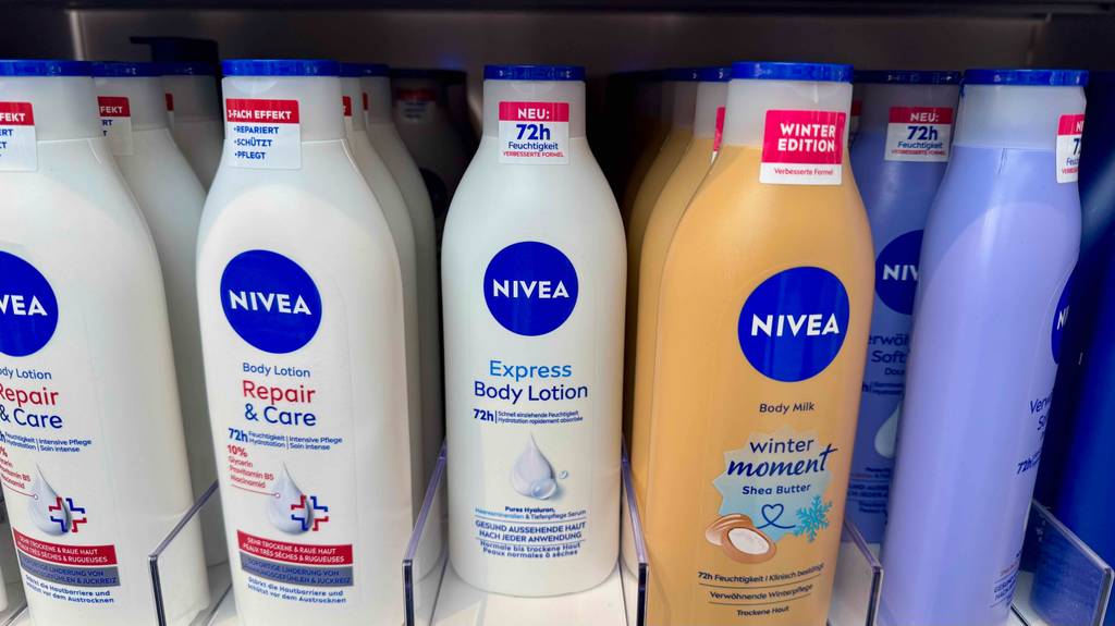 Eine weiße Flasche mit getesteter Nivea-Bodylotion steht neben weiteren Nivea-Körpermilch-Produkten in einem Verkaufsbereich.
