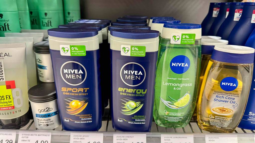 Mehrere dunkelblaue Quetschflaschen mit getestetem Nivea-Duschgel für Männer stehen in einem Verkaufsregal neben weiteren Nivea-Produkten.