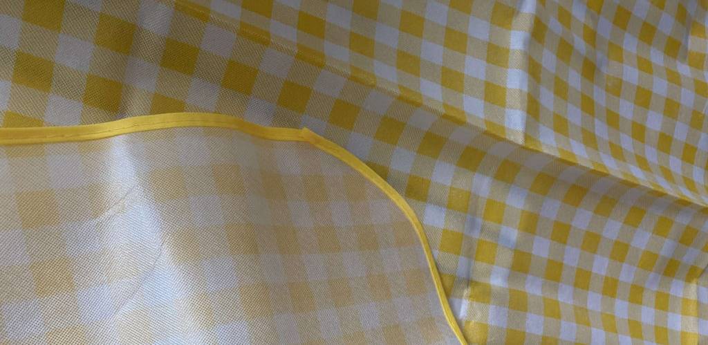 Detailansicht des Materials einer gelb-weiß-karierten Picknickdecke im Test.