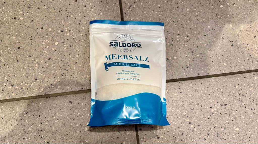 Ein 500-g-Beutel getestetes Salz ohne Zusätze liegt auf einem Fliesenbelag.