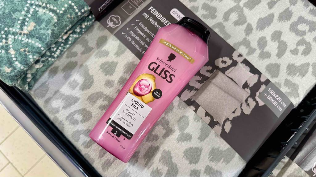 Ein getestetes Schwarzkopf-Shampoo liegt auf einer Packung Feinbiberbettwäsche.