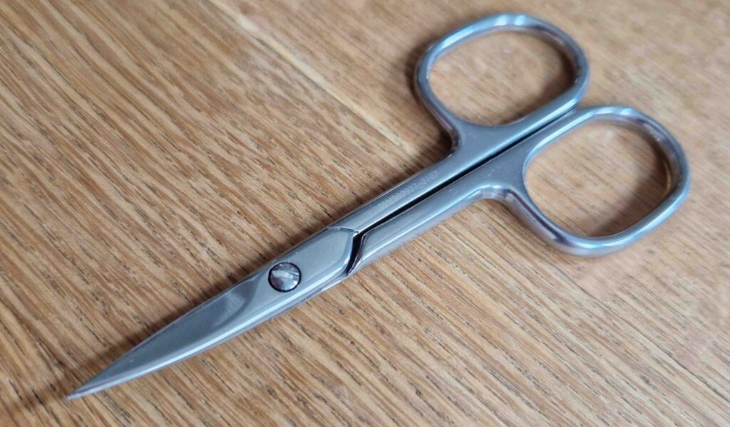 Nagelscheren-Test: Nahaufnahme eines rostfreien Modells, das auf einer Holzoberfläche liegt.