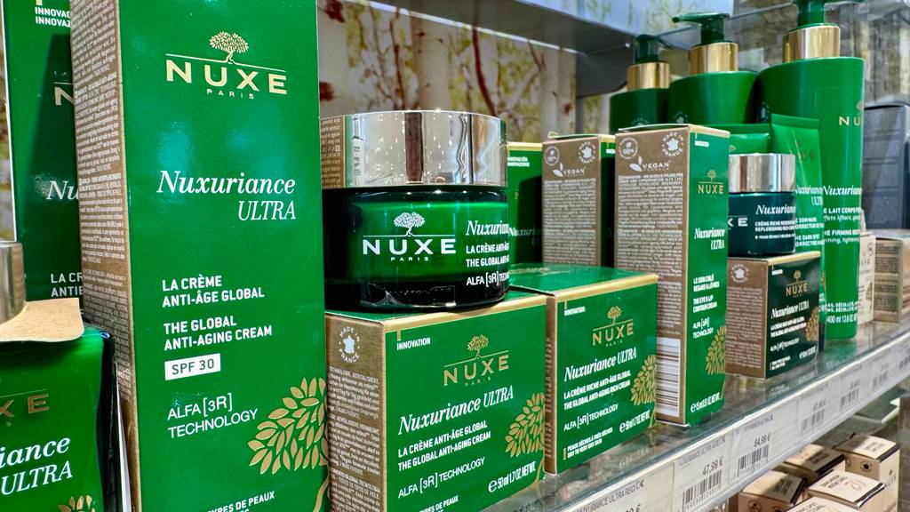 Auf einem Regal, auf dem sich die Nuxe-Produkte in den grünen Verpackungen befinden, steht auch ein Tiegel mit der getesteten Gesichtscreme von Nuxe.