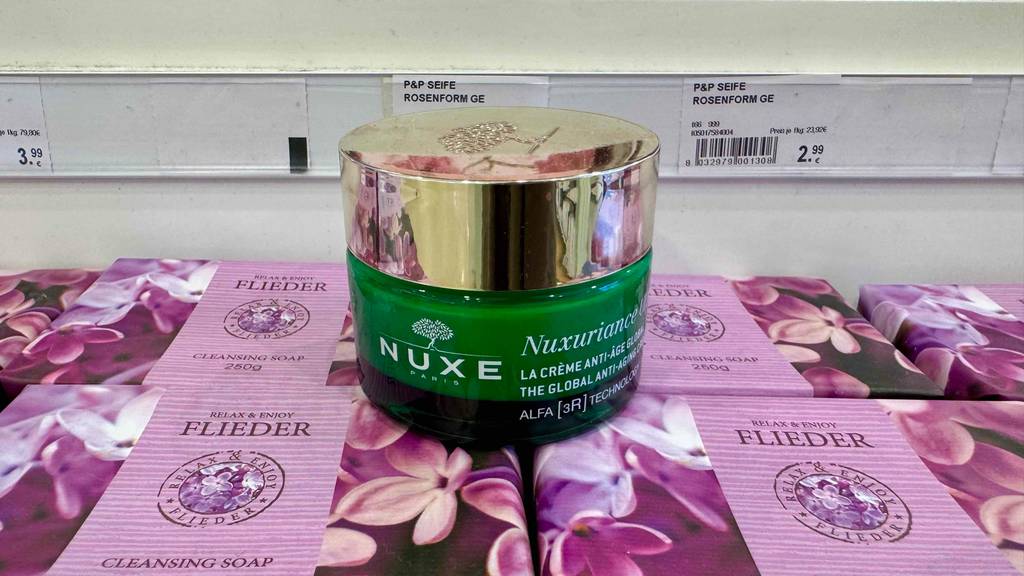 Nahaufnahme der getesteten Gesichtscreme von Nuxe, die im 50-ml-Tiegel auf mehreren Packungen mit Flieder-Seife steht.