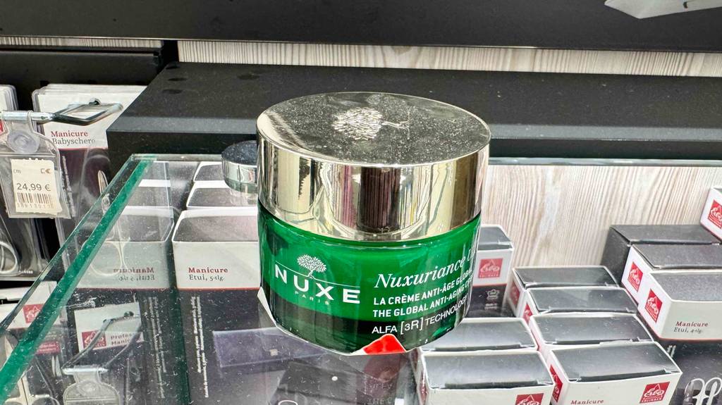 Die getestete Gesichtscreme von Nuxe im 50-ml-Tiegel steht auf einem Verkaufsregal mit Kosmetikprodukten.
