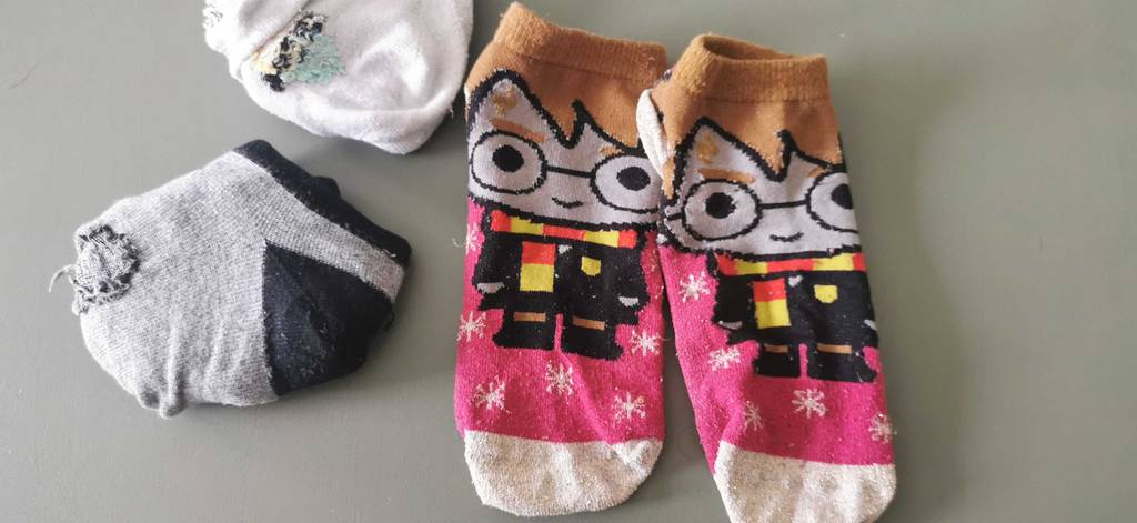 Mehrere Sneaker-Socken, unter anderem platzsparend gefaltet.